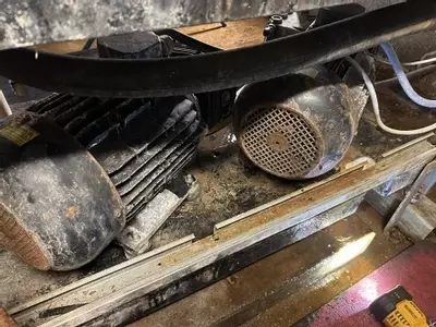 Old electric motors fitted to multi-pump pressure washer system before repair at a malt house in Burton.